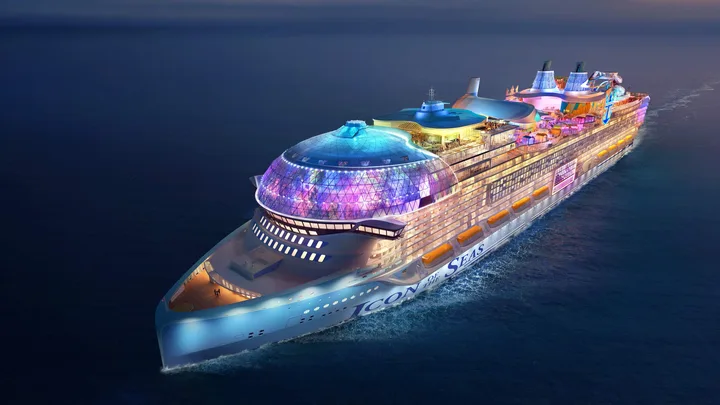 A futuristic cruise ship named "Icon of the Seas" sailing at night with vibrant lights illuminating its decks.