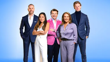 Group of five business professionals in formal attire, posing confidently against a blue gradient background.