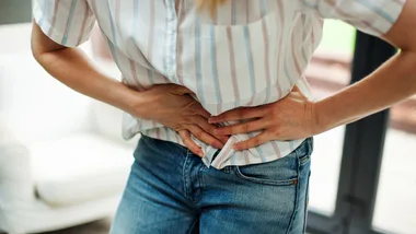 Woman holding stomach in pain