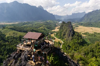 TOPSHOT - Tourists look at the surroundings from Namxay Viewpoint in Vang Vieng on November 24, 2024. The Laos government said on November 23 it was "profoundly saddened" by the deaths of foreign tourists in Vang Vieng, with the toll from a suspected methanol poisoning incident now at six. Six tourists died of suspected methanol poisoning after a night out in the Laos backpacker hotspot of Vang Vieng last week. (Photo by AFP) (Photo by STR/AFP via Getty Images)