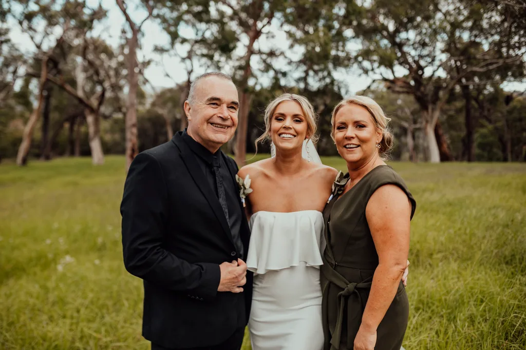 Jess Ragusa, who has cystic fibrosis with her parents on her wedding day.