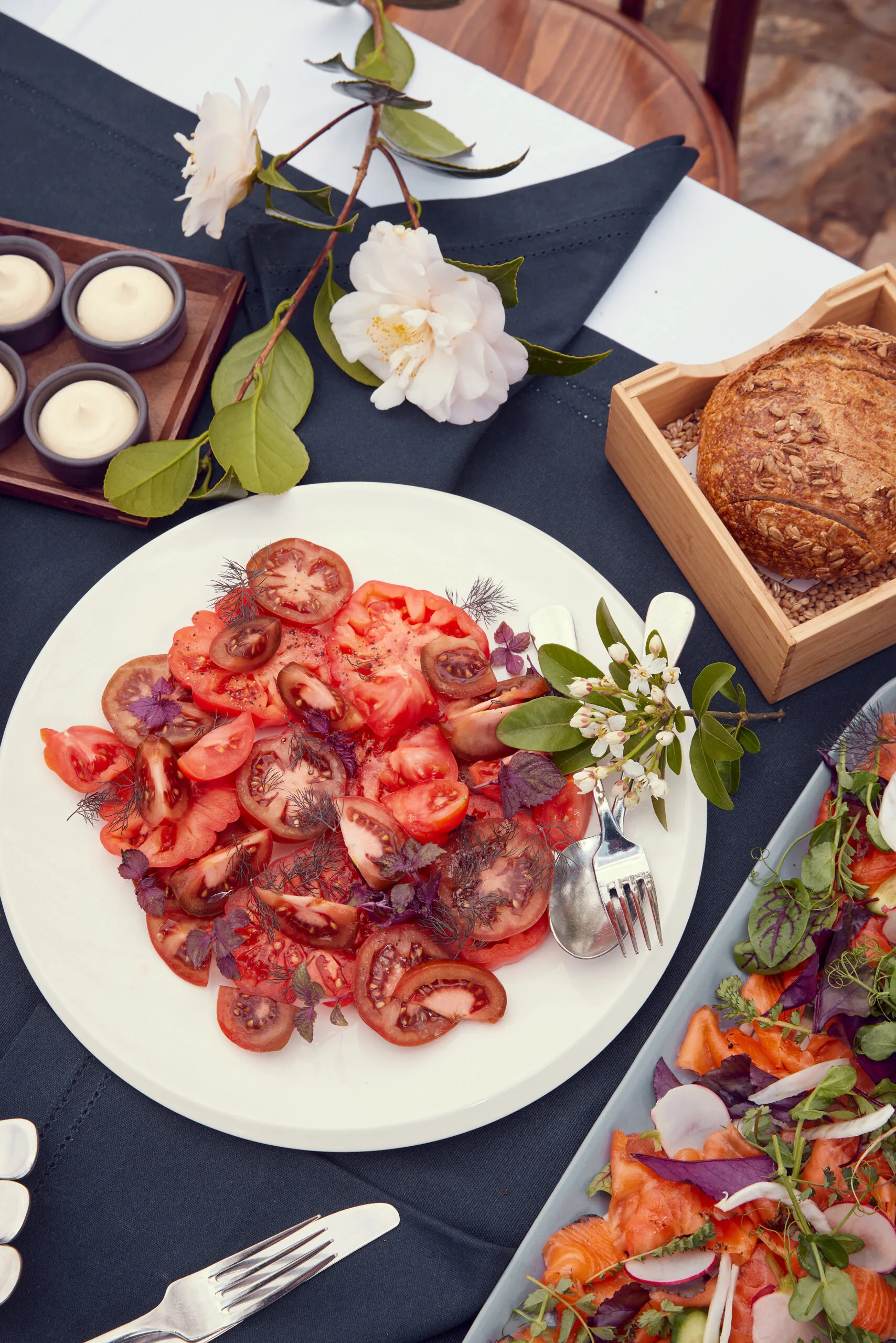 A plate of fresh, sliced heirloom tomatoes and herbs on Alla Wolf-Tasker's table.