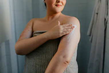 A woman moisturising her arms as a treatment for keratosis pilaris.