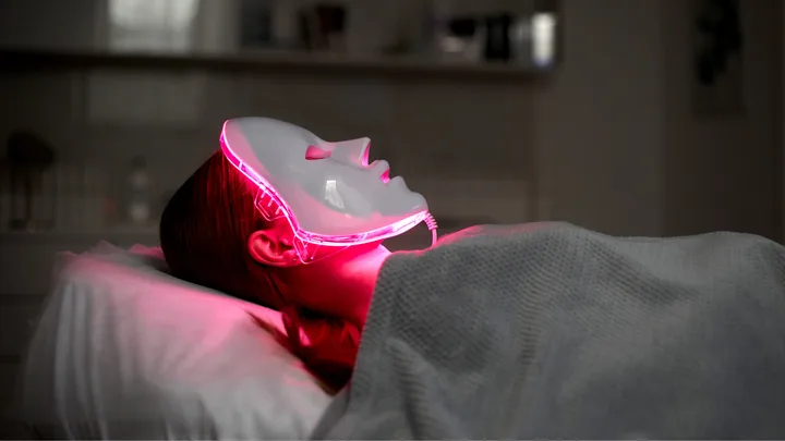 A woman receiving red light therapy treatment.