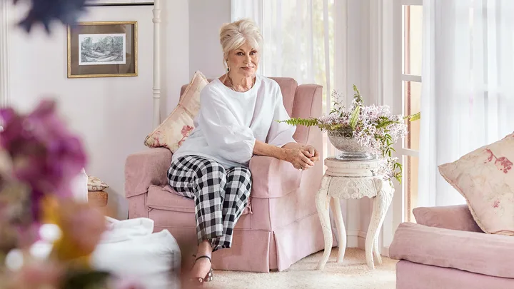 Di sits on a pink couch