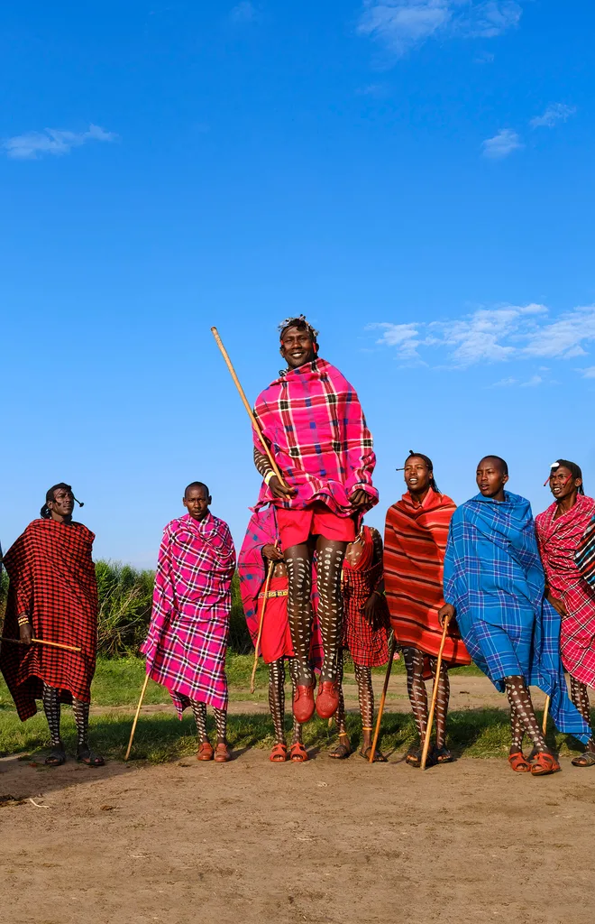 A young Kenyan man jumps into the air.