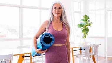 Woman with yoga mat at home