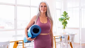 Woman with yoga mat at home