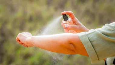 Woman spraying insect repellent