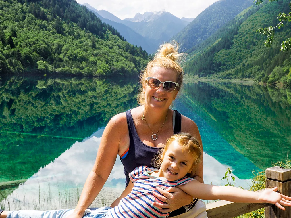 A white woman and her daughter in front of a lake.