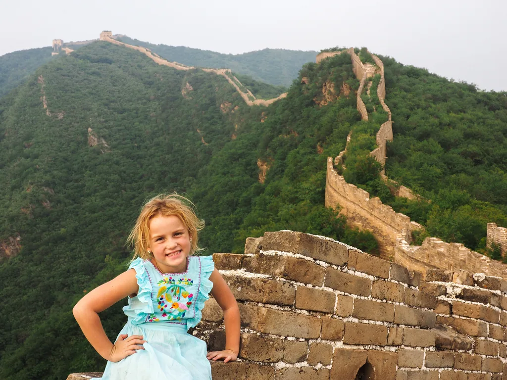 Emmie, a young white girl with blonde hair, at the Great Wall of China
