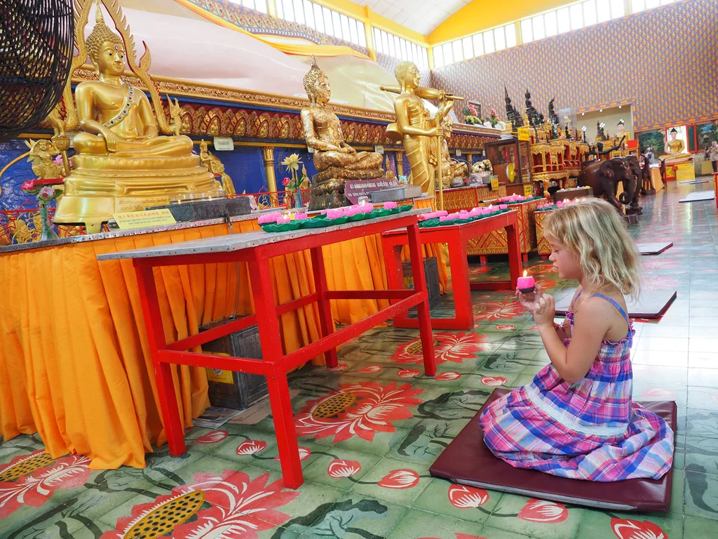 A young girl kneels in a temple