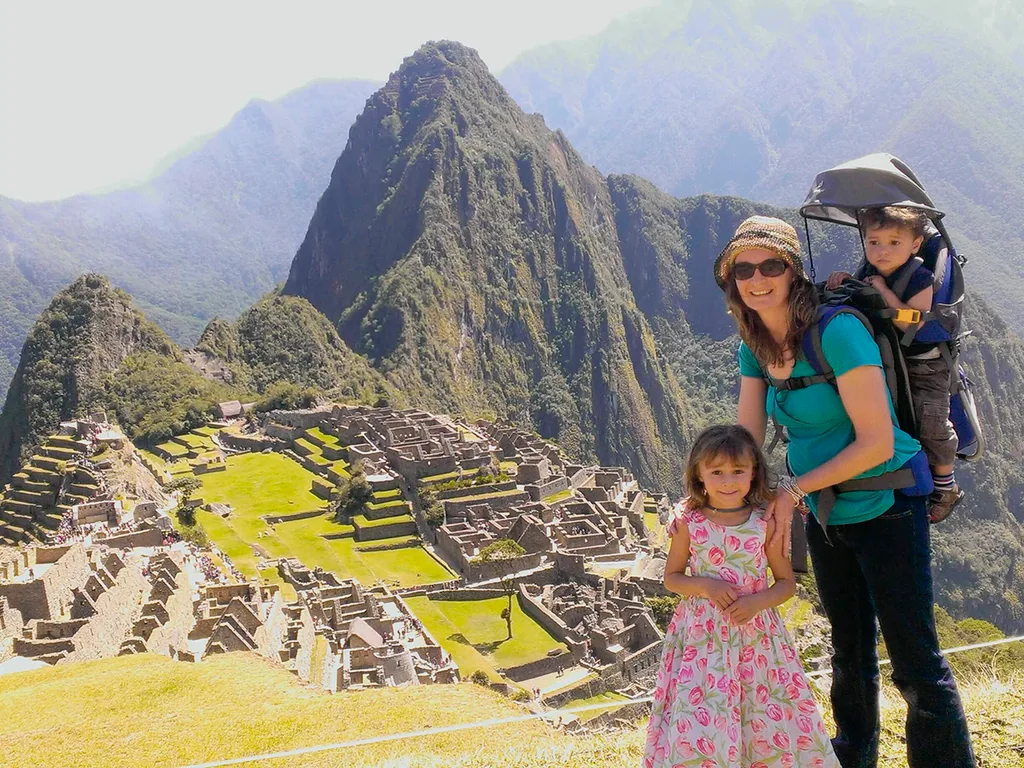 A mother with two kids in front of historic ruins.
