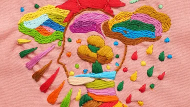 Embroidered art of a head surrounded by colourful shapes