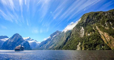 Cruise ship on the water in front of mountains.