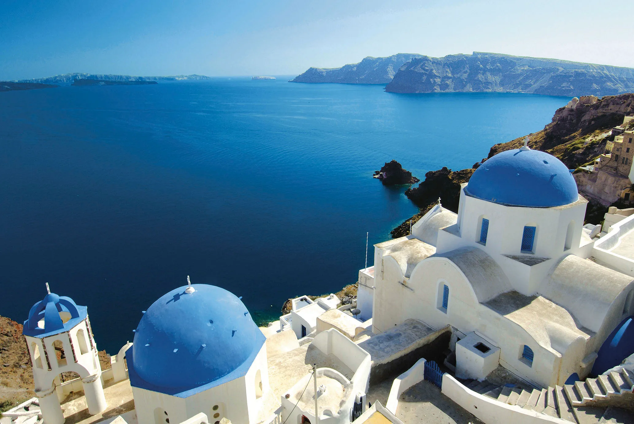 white and blue building in Greece, Santorini, overlooking the water