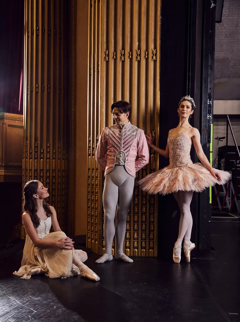 Three Australian Ballet ballerinas, two women one man, on stage in The Nutcracker costumes.
