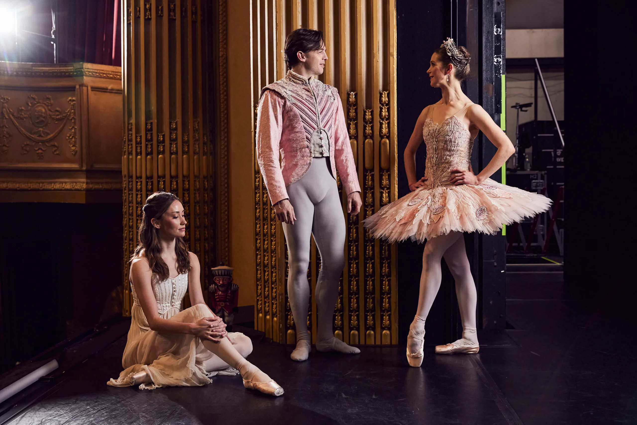 Three Australian Ballet ballerinas, two women one man, on stage in The Nutcracker costumes.