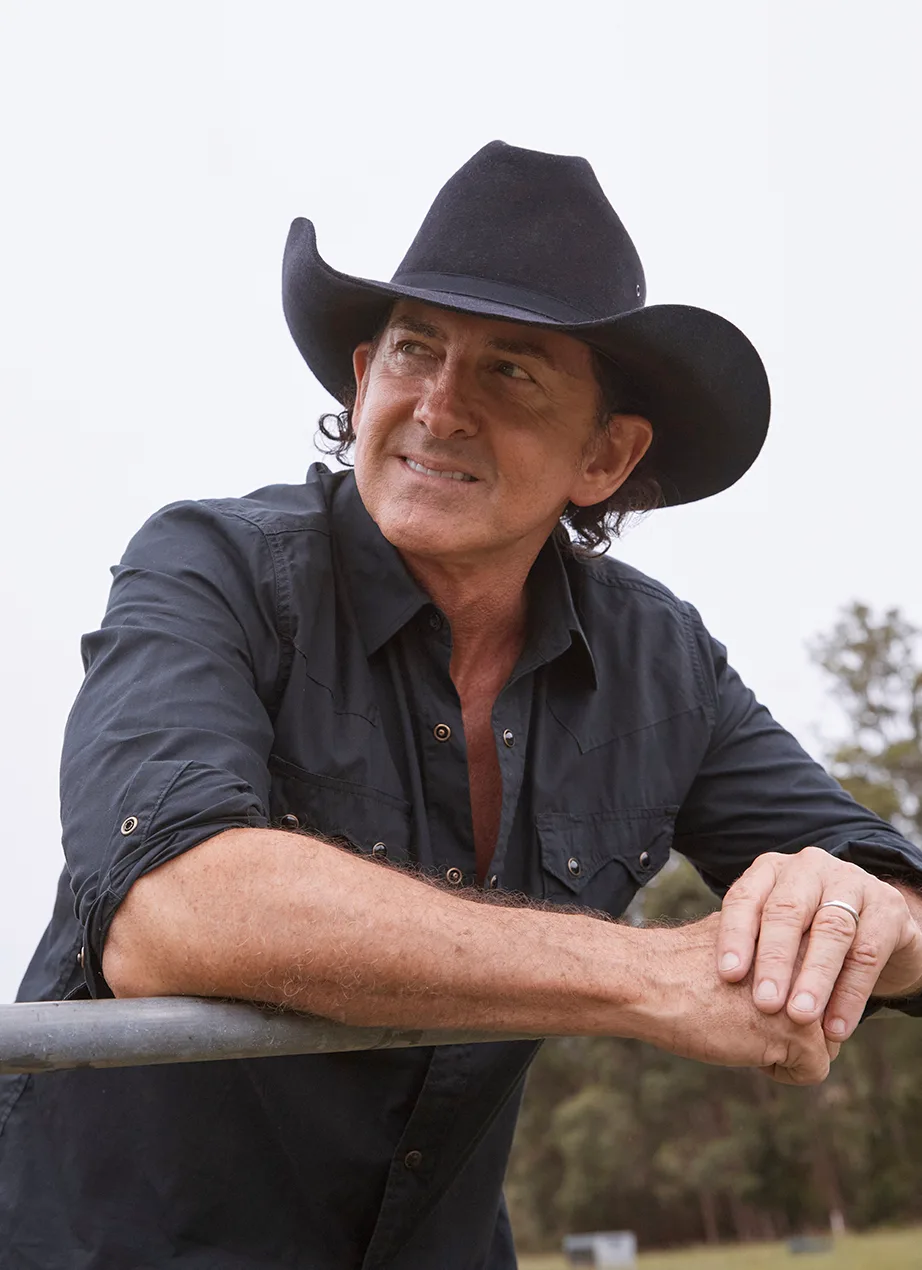 Lee Kernaghan leaning on a fence.