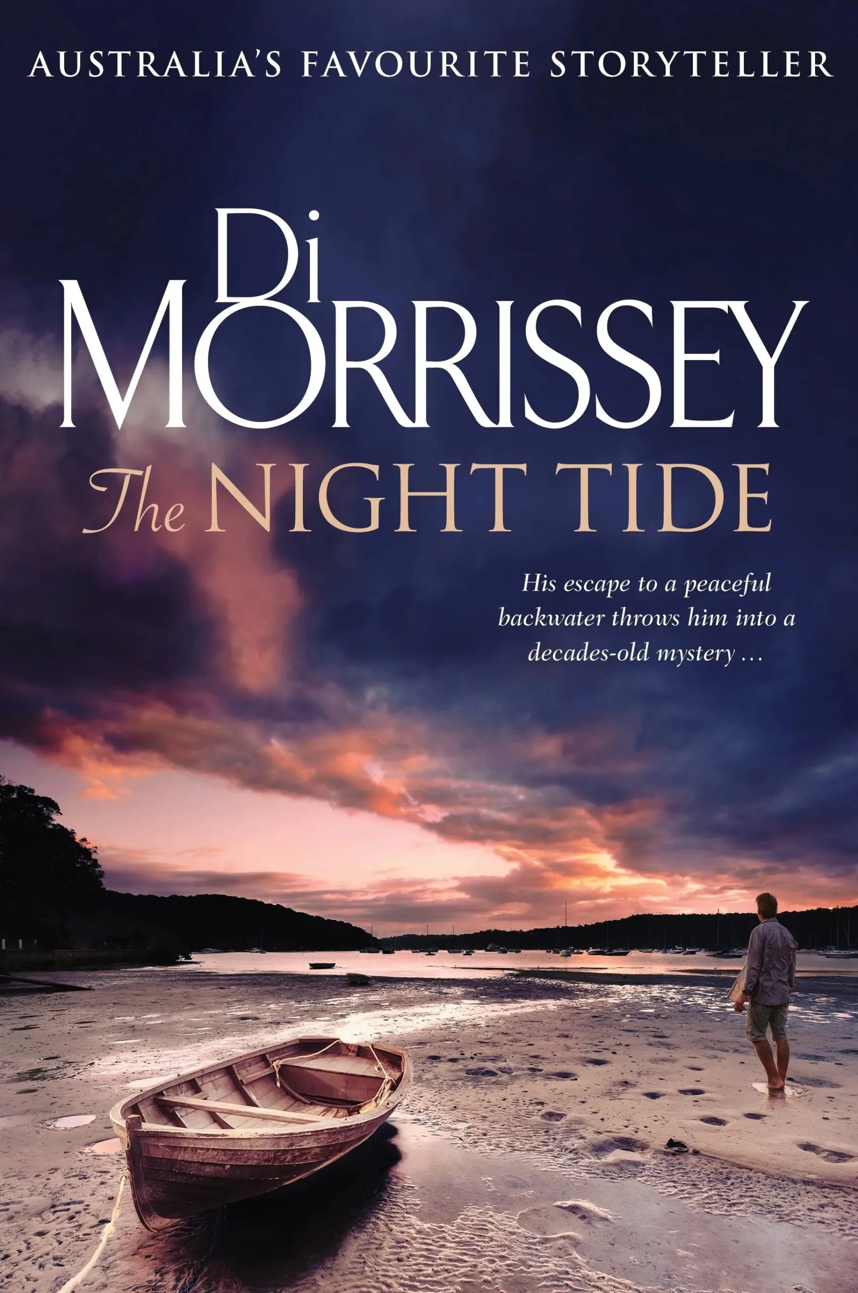 Book cover of Di Morrissey's The Night Tide. A man stand on a beach with a small wooden boat.