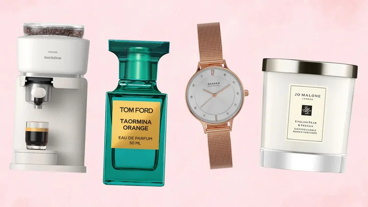 A collection of four lifestyle products - a Philips white espresso machine, a teal bottle of Tom Ford perfume, a rose gold mesh watch, and a Jo Malone scented candle - arranged against a light pink background.