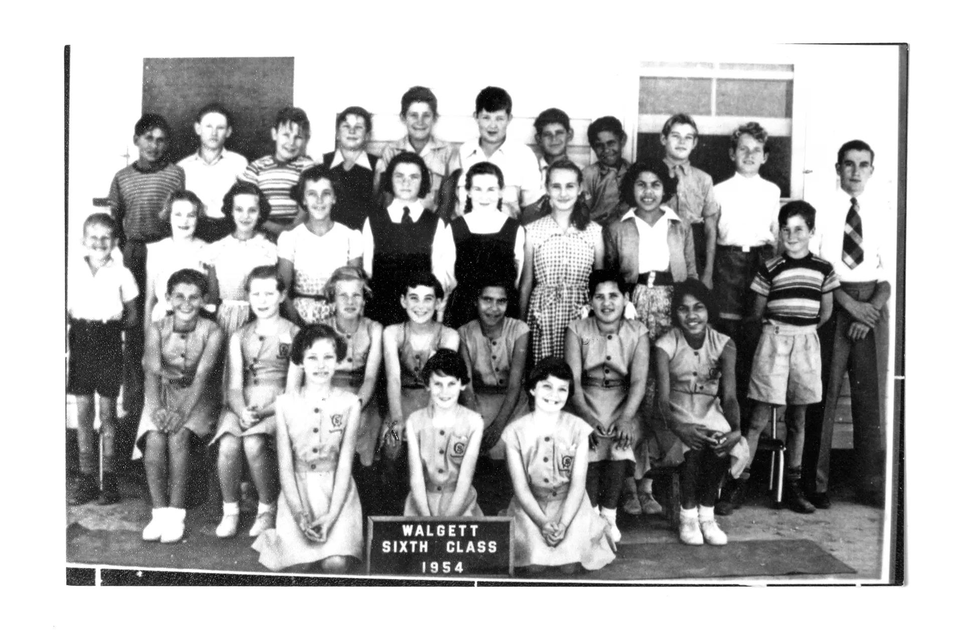 A black and white class photo of school children from 1954.