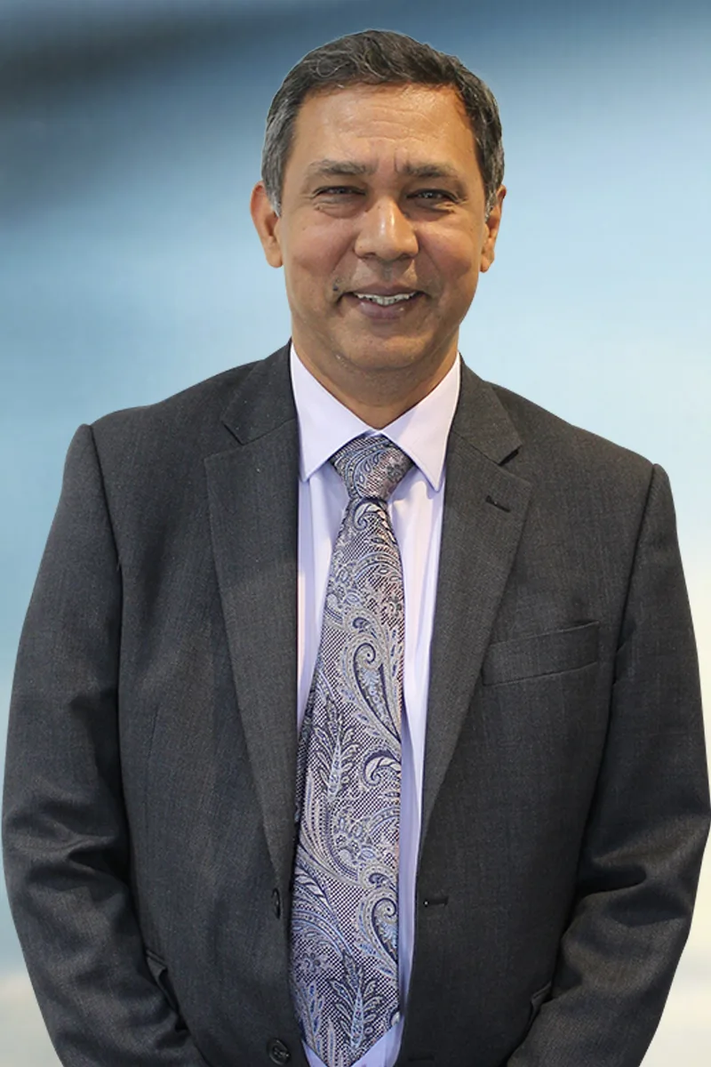 Dr Ashwini Padhi wears a grey suit with a mauve shirt and a paisley tie. He looks into the camera smiling.