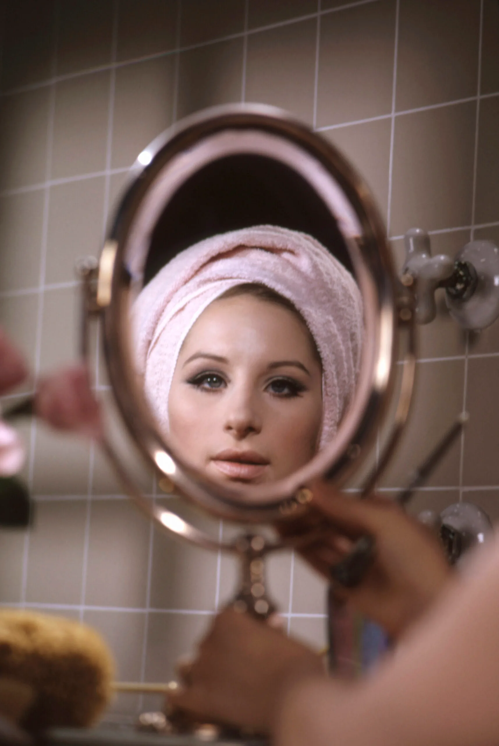 Barbra Streisand looks at her reflection in bathroom mirror as Fanny Brice from the 1968 movie 'Funny Girl'. (Photo by Screen Archives/Getty Images)
