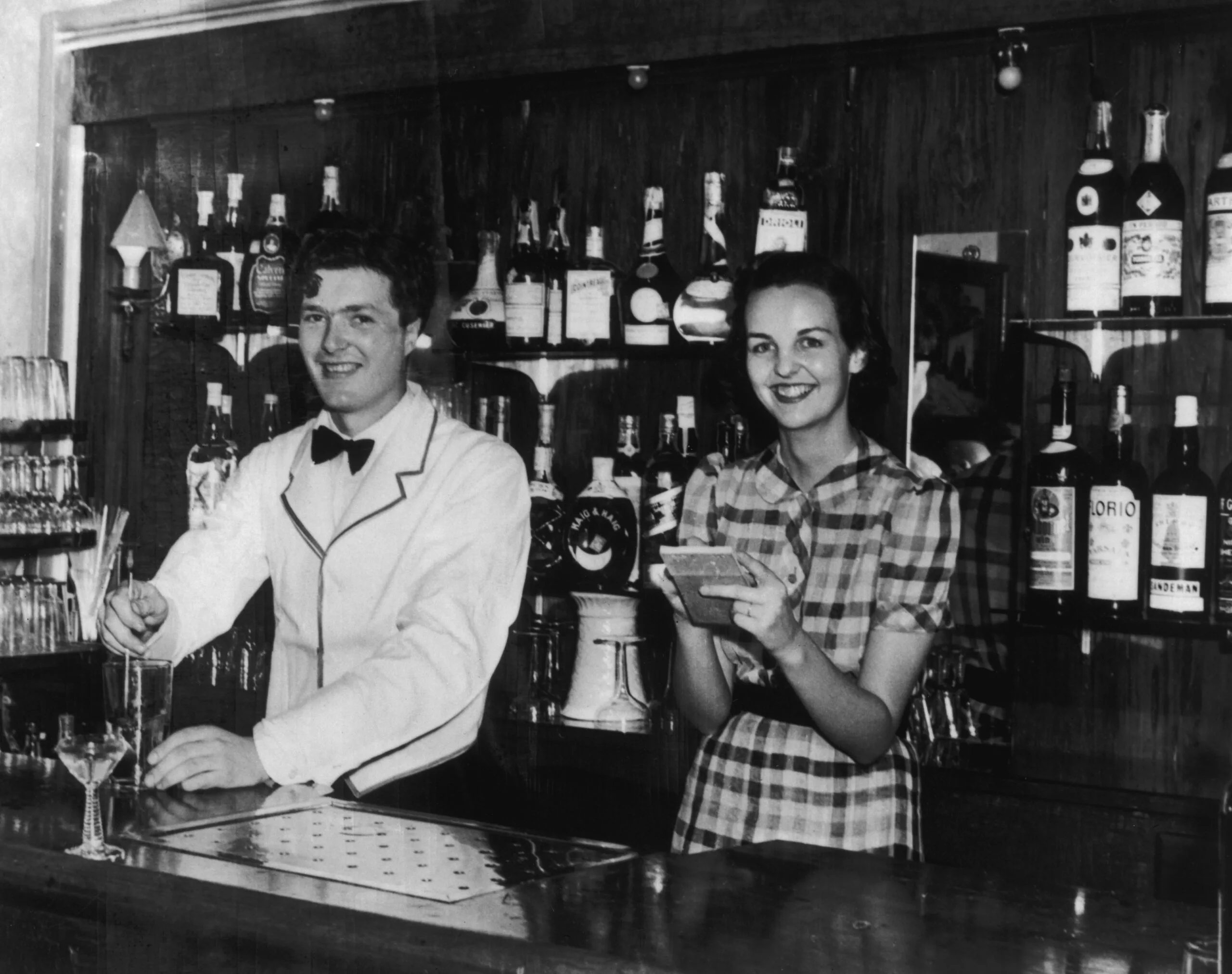 British investigative journalist and writer Jessica Mitford (1917 - 1996) with her husband Esmond Romilly (1918 - 1941), nephew of Winston Churchill, behind the bar of the Roma Restaurant in Biscayne Bay, Miami, 25th January 1940. They opened the bar together after their elopement. (Photo by Keystone/Hulton Archive/Getty Images)