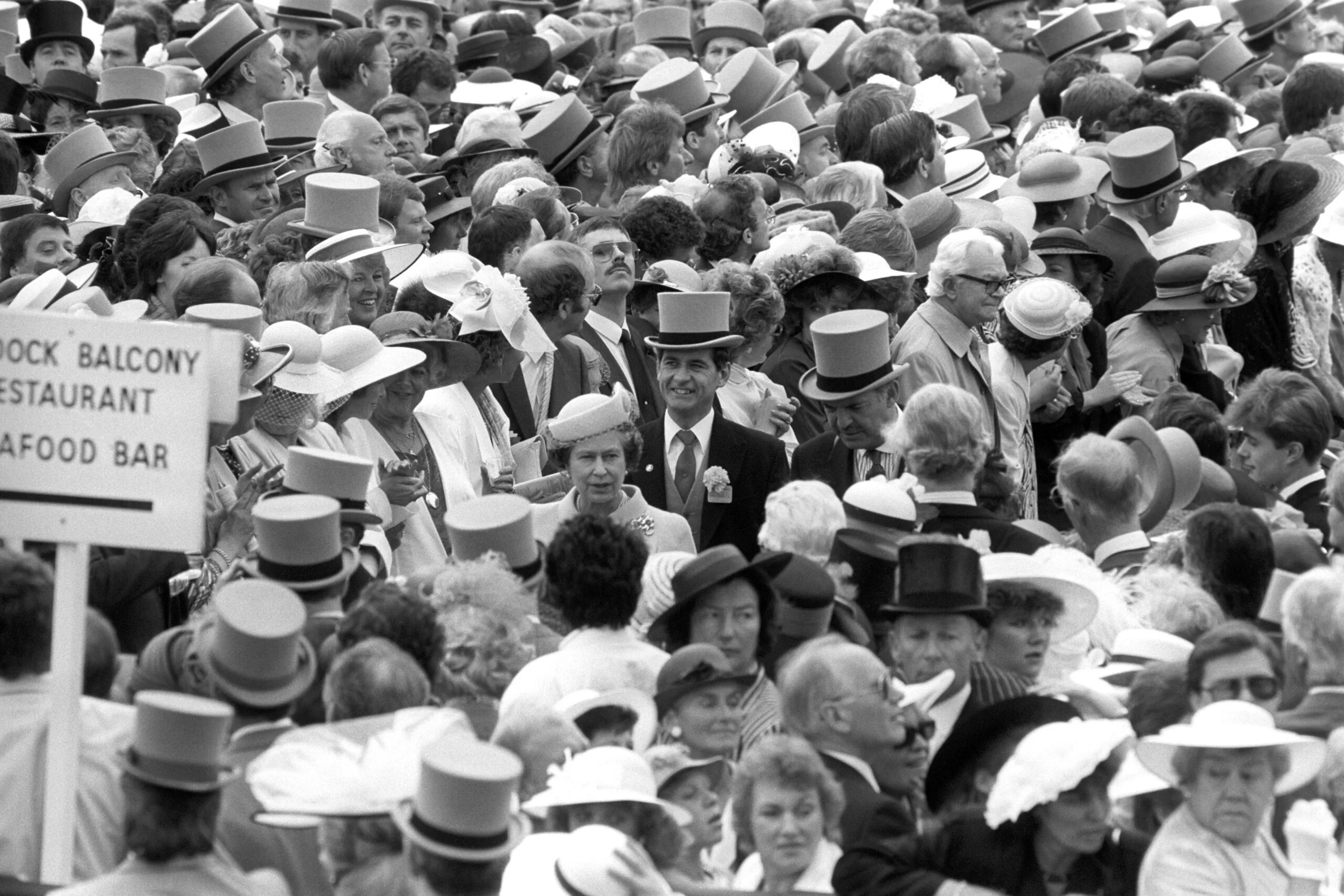 Queen Elizabeth II is surrounded by a sea of faces as she arrives at Royal Ascot. Behind her, left, smiling with top hat is Chief Superintendent Jim Beaton, the Queen's Police Officer. (Photo by Ron Bell/PA Images via Getty Images)