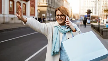 Amazon Prime Day tech deals that are calling to us, much like this happy woman who is calling for a taxi after shopping.