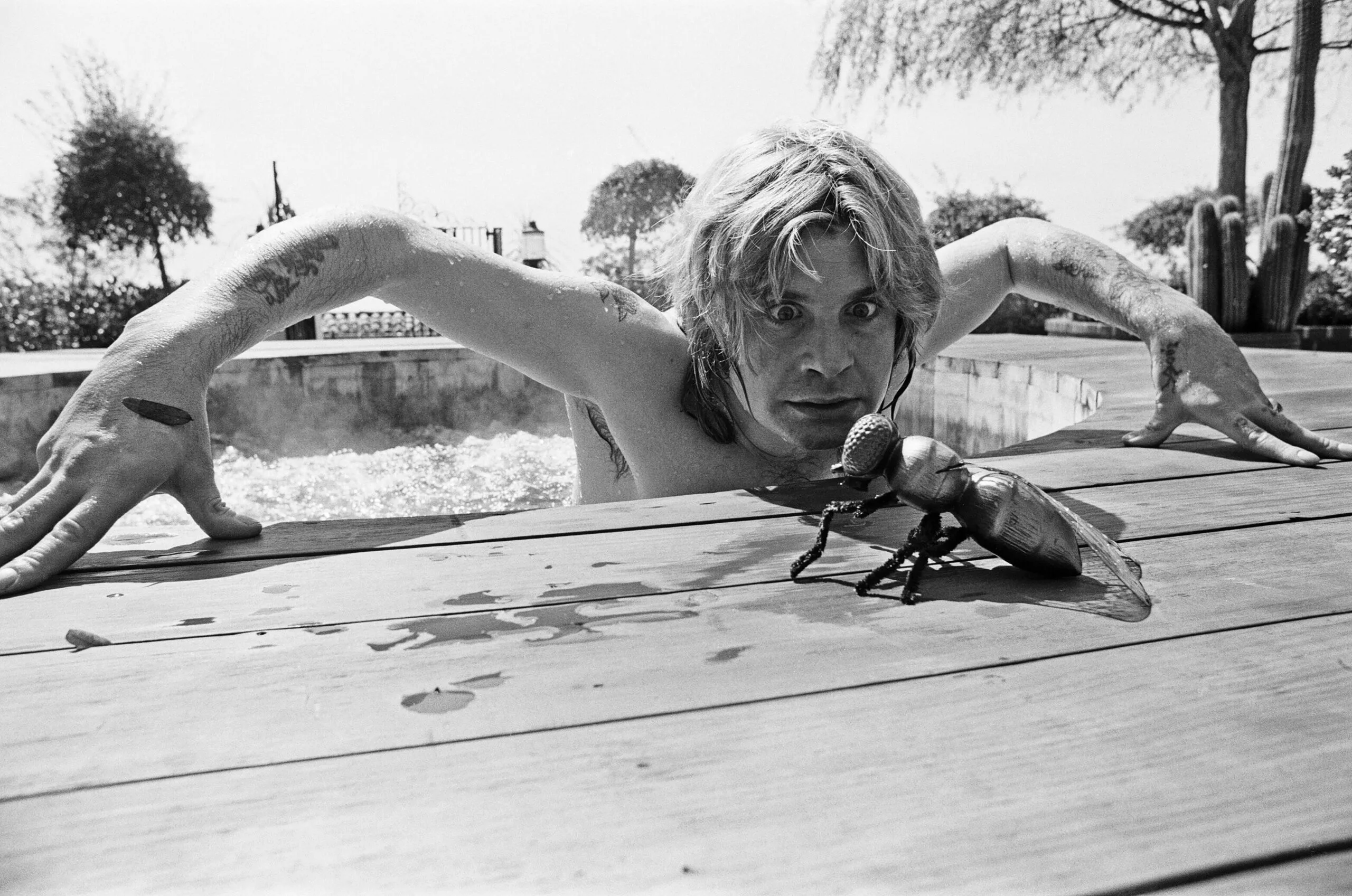 Ozzy Osbourne, former lead singer of Black Sabbath, pictured in his open air hot tub in the garden of his luxury home in Goldwater Canyon, Beverly Hills,California with giant rubber fly. 28th April 1982.(Photo by Eddie Sanderson/Getty Images).
