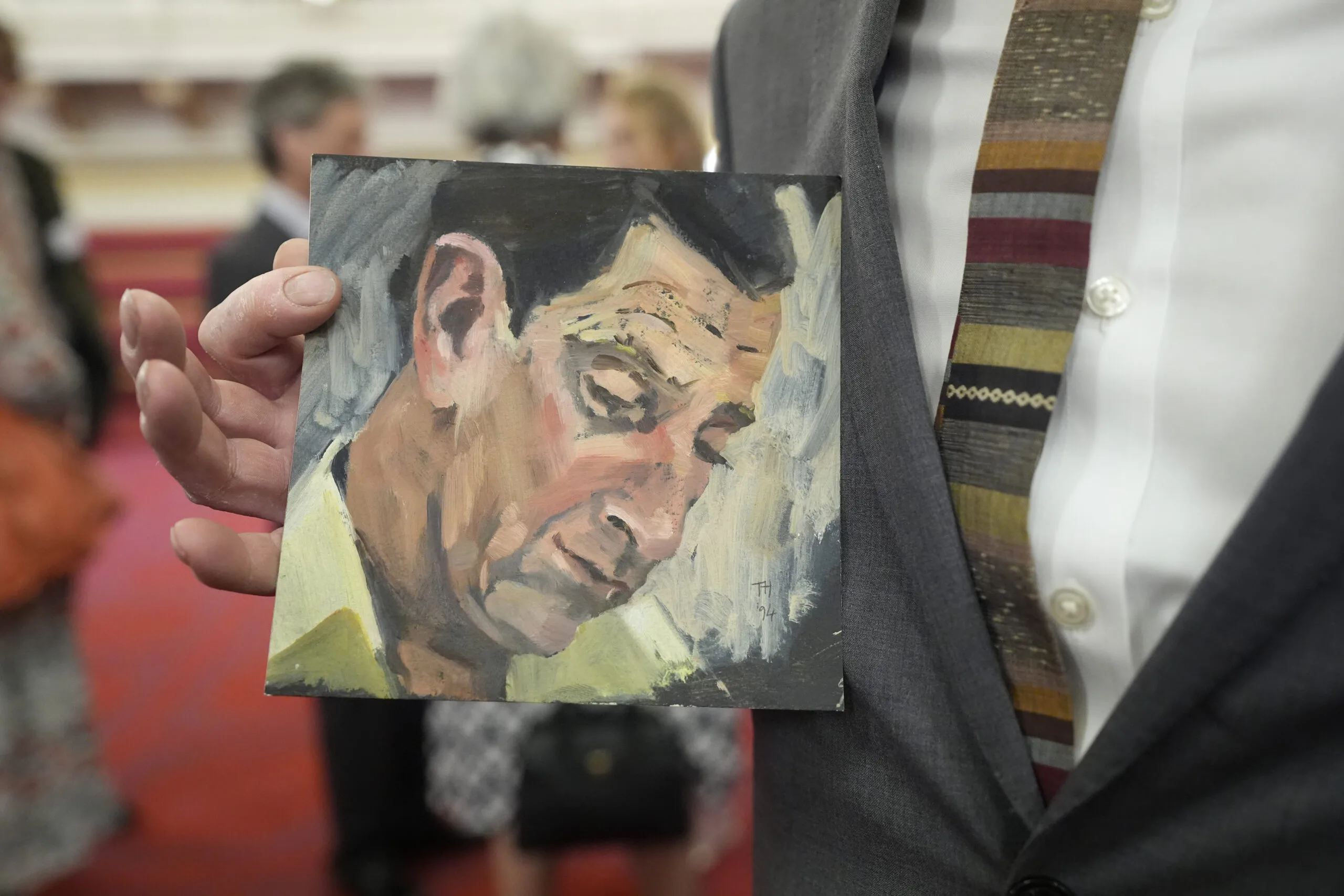 LONDON, ENGLAND - JULY 9: Tom Halifax holds a painting which he gave to King Charles III during a reception for the King's Tour Artists exhibition celebrating 40 years of artists accompanying official overseas visits at Buckingham Palace, on July 9, 2025 in London, England. The exhibition features the work of 43 artists who have joined the King on 70 official visits across 95 countries and regions. (Photo Andrew Matthews - WPA Pool/Getty Images)