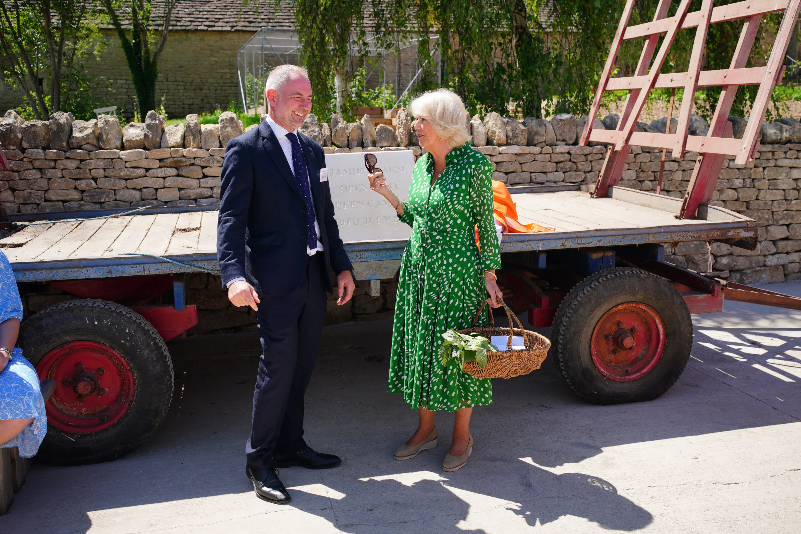 BATHFORD, ENGLAND - JULY 10: Queen Camilla, Patron of Jamie's Farm, presents founder and co-CEO Jamie Feilden with a basket of produce and seeds from her personal garden to be used at Jamie's Farm, during a visit to officially open the charity's latest site at Lower Shockerwick Farm on July 10, 2025 in Bathford, England. Established by Tish Feilden and her son Jamie, Jamie's Farm offers young people who are experiencing challenges at school, opportunities to take park in immersive programmes on working farms across the UK. (Photo by Ben Birchall-WPA Pool/Getty Images)