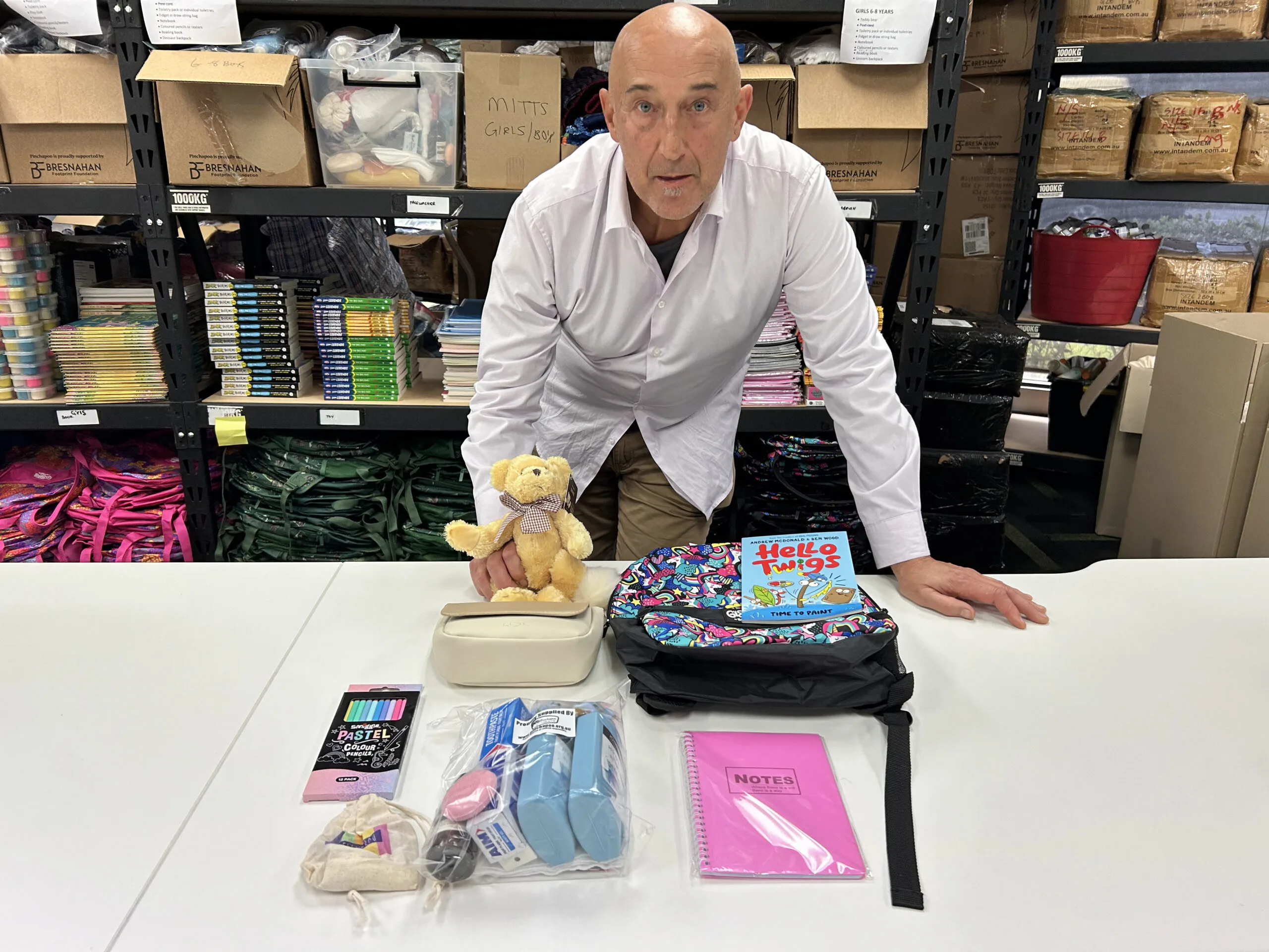 Walter Mikac stands at a table with the contents of a Buddy Bag laid out before him.