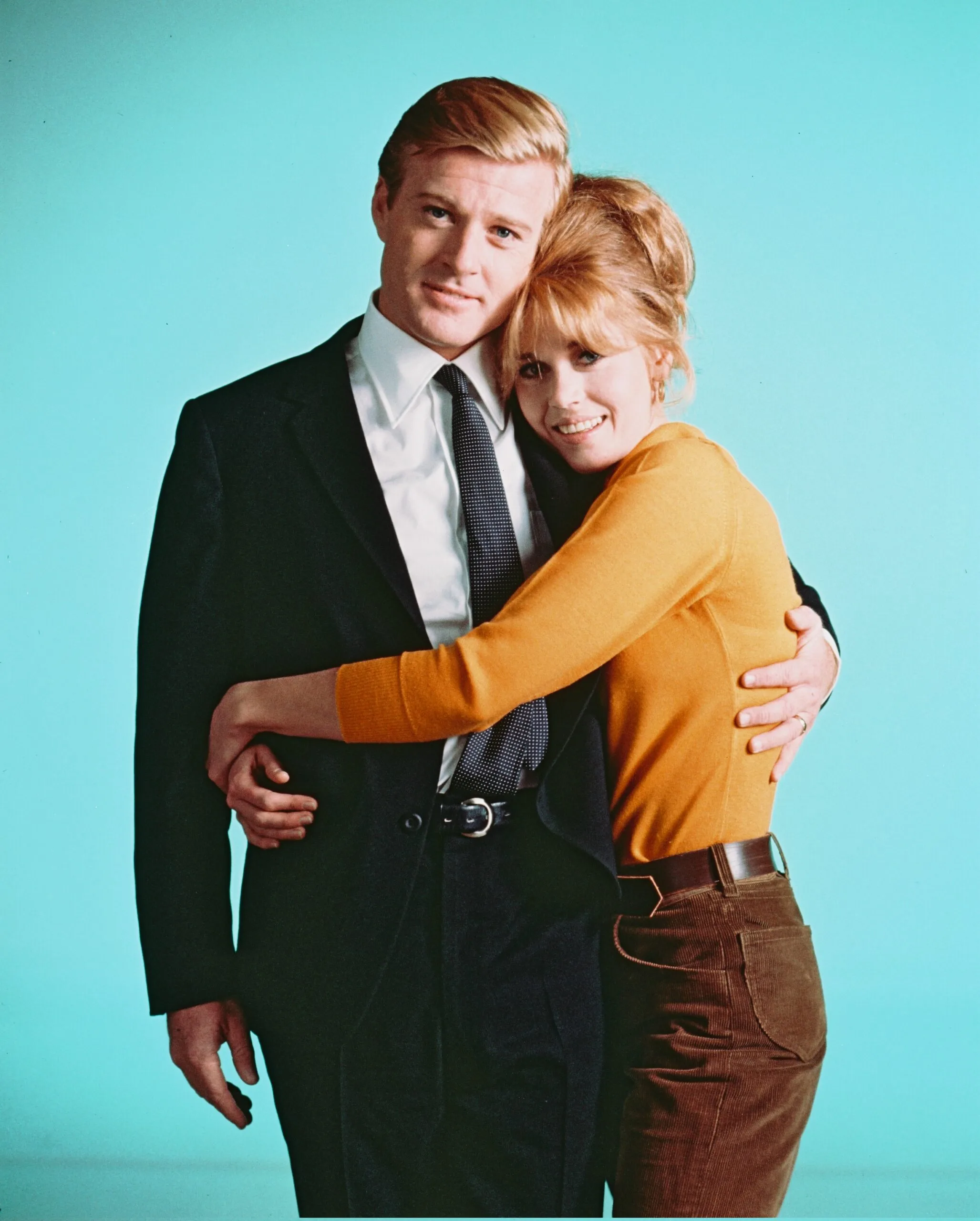 Robert Redford, US actor, and Jane Fonda, US actress, cuddling as they pose for a studio portrait, against a light blue background, issued as publicity for the film, 'Barefoot in the Park', USA, 1967. The Neil Simon comedy, directed by Gene Saks, starred Redford as ' Paul Bratter', and Fonda as 'Corie Bratter'. (Photo by Silver Screen Collection/Getty Images)