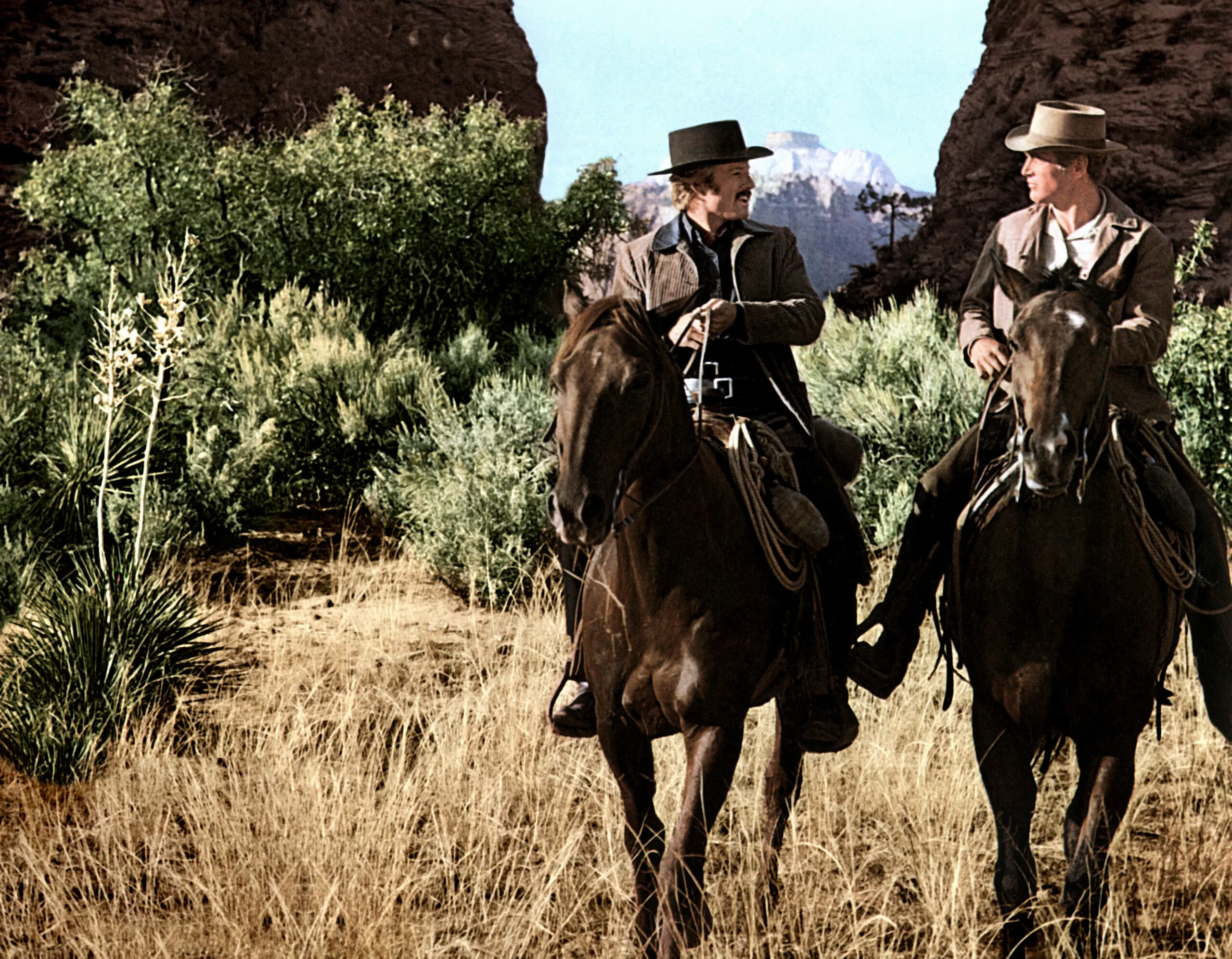 Paul Newman and Robert Redford chatting whilst on horseback in a scene from the 1969 western 'Butch Cassidy and the Sundance Kid'. (Photo by Screen Archives/Getty Images)