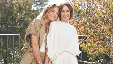 two women stand side by side, one leaning on the other's shoulder