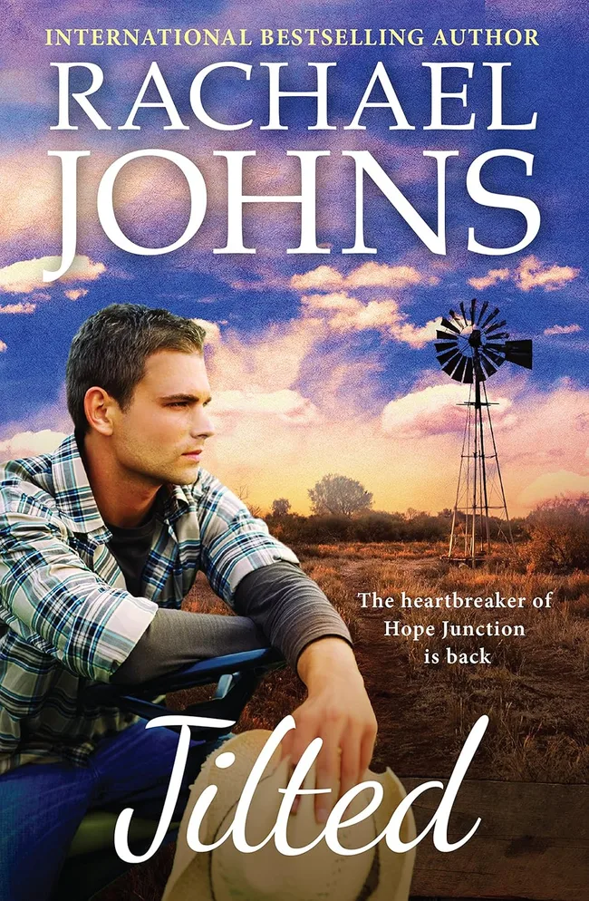 Rachael Johns jilted book cover. A man holding a cowboy hat, with a bush landscape in background.