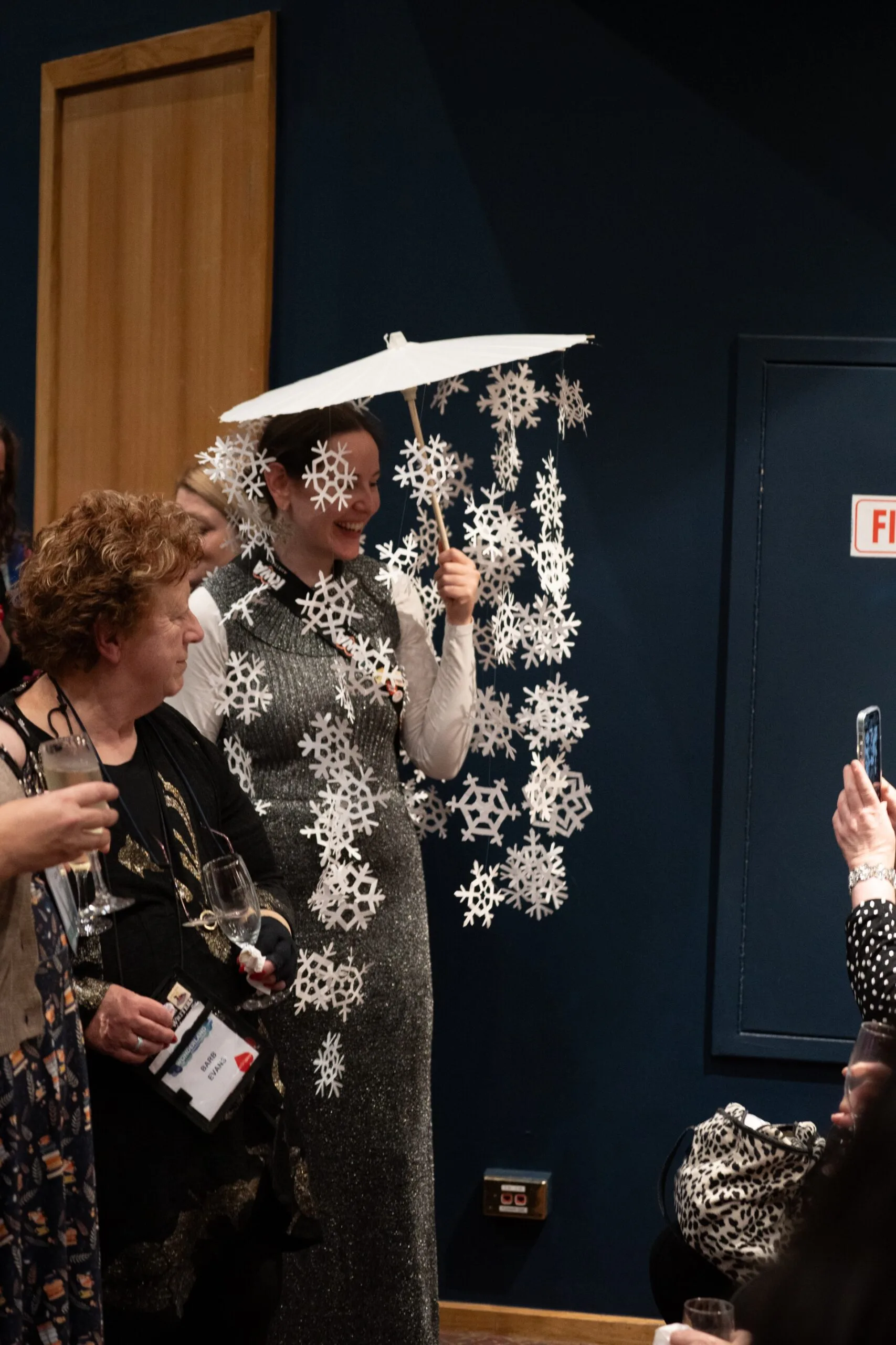 a woman holding a parasol with paper snowflakes attached