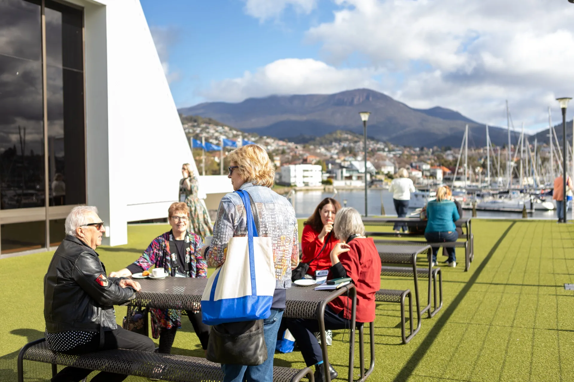 People sitting at a table outside on a sunny day.