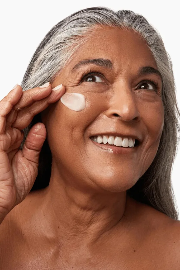 Mature women applying Boost Lab moisturiser to her face