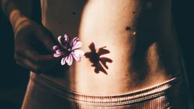 Young woman belly with flower