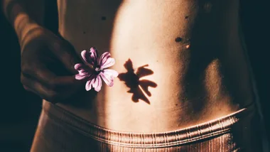 Young woman belly with flower