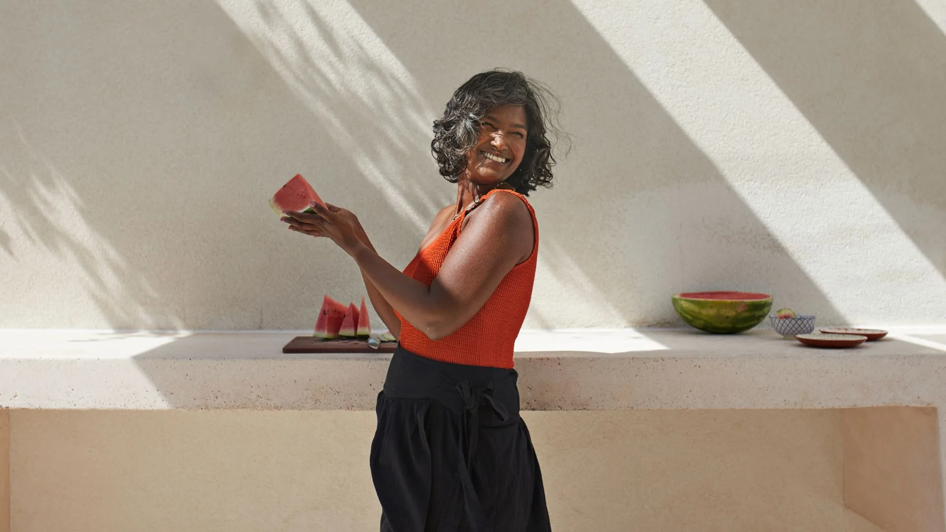 Happy middle aged women outside holding watermelon
