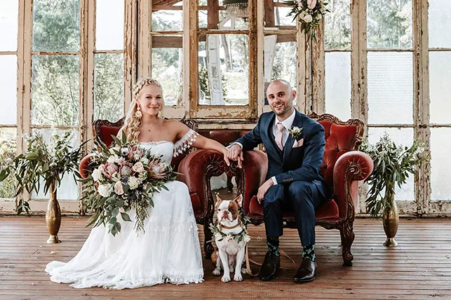 Paralympic athletes Vanessa Low and Scott Reardon on their wedding day, sitting on two red velvet chairs