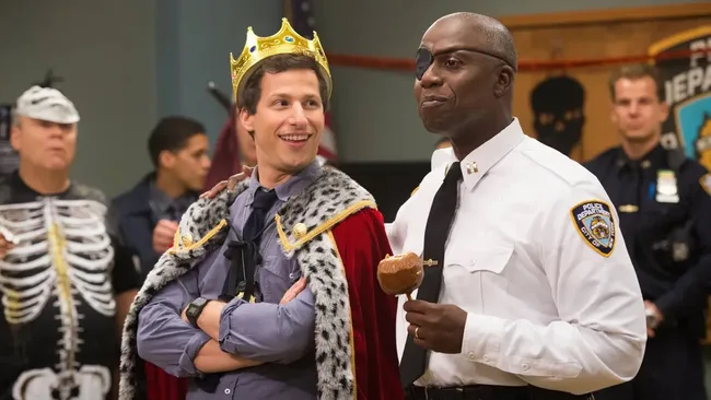 A man dressed as a king, and another wearing an eyepatch. Brooklyn Nine-Nine, Halloween tv episode.
