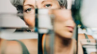 Mature lady looking through glasses of water
