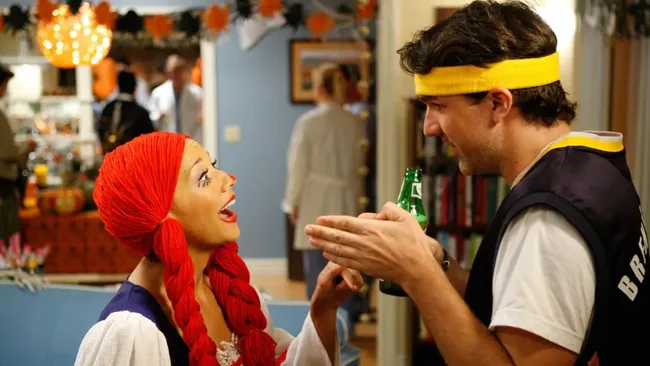 A woman dressed a Pippi Longstockings and a man dressed a basketball player. Parks and Recreation, Greg Pikitis halloween tv episode.