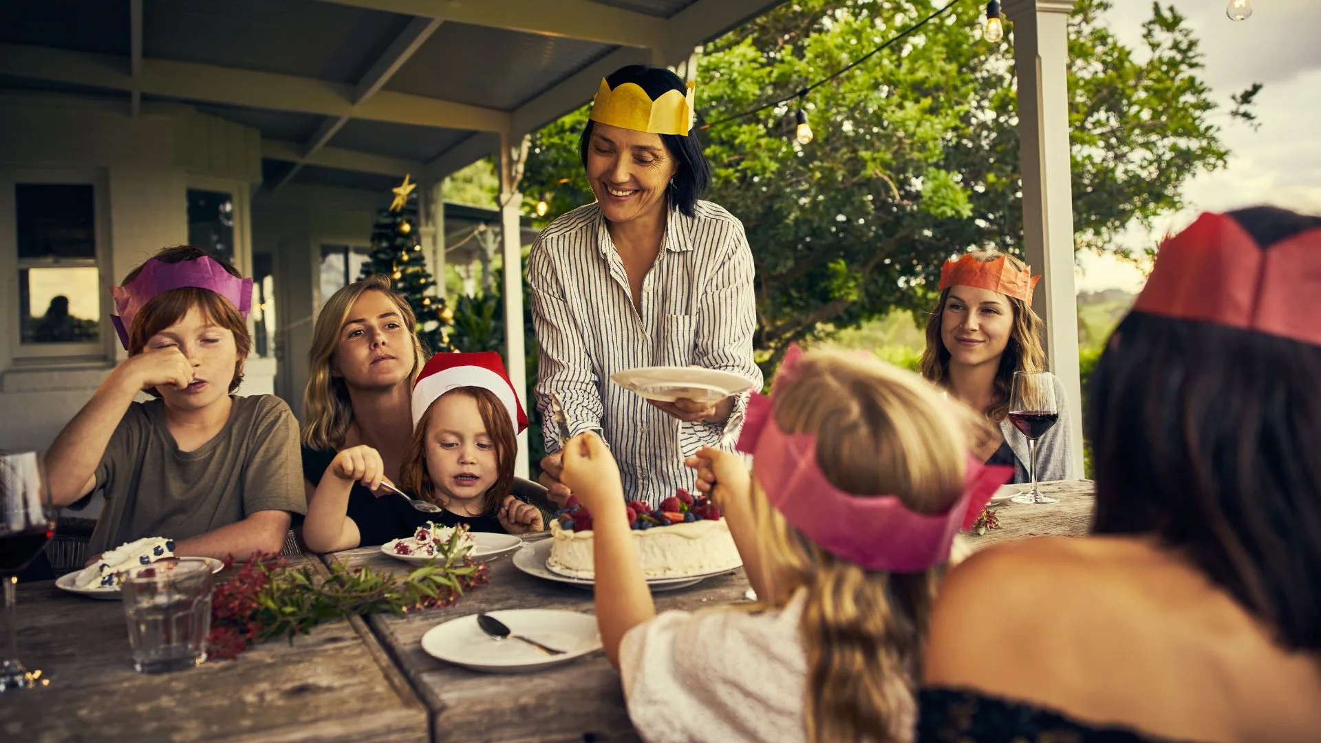women and family serving Christmas lunch at table outside